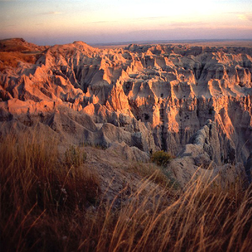 The sun casts a red glow over Badlands National Park in South Dakota , photo