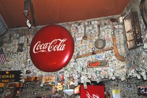 Inside the Oatman Hotel Restaurant-Bar hangs hundred and hundreds of one dollar bills signed by the many visitors of this historic hotel, Kathy Weiser.