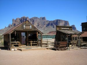 The superstition Mountains can be seen behind these  old buildings in nearby Goldfield, Arizona