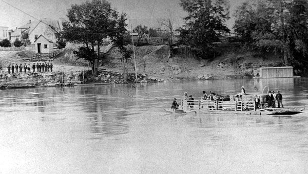 A Covered Wagon is ferried across a river