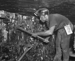 Coal miner working with a pick and shovel.