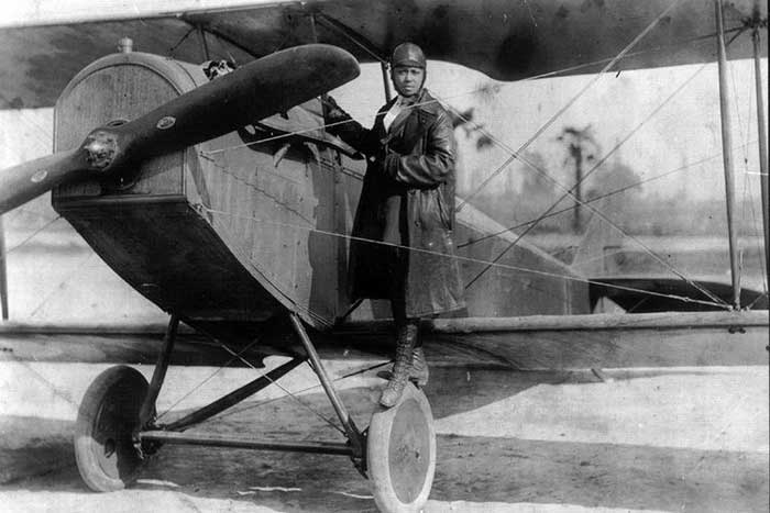 Bessie Coleman with her Curtiss JN-4 "Jennie" in her custom designed flying suit, 1924. Photo courtesy Smithsonian Magazine.