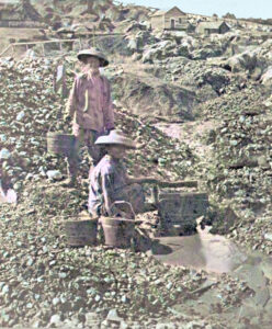 Chinese gold miners working along a small stream.